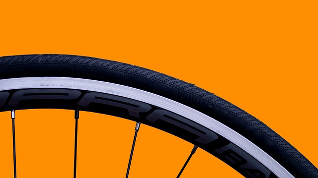 Close up photo of bicycle wheel, with orange background.