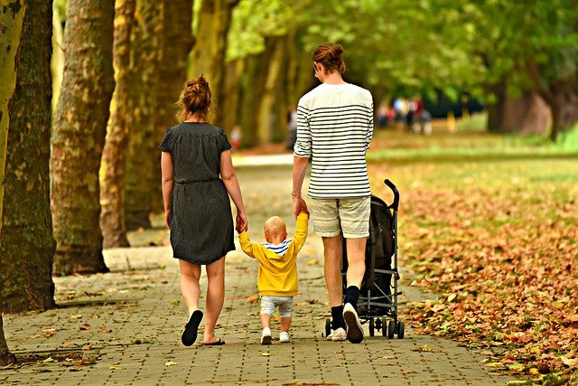 Mom, dad, and toddler walking in park