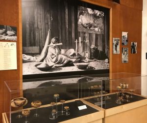 Photograph of a Museum exhibit, two cases filled with small and very small Pomo baskets.