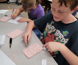 Two children are drawing at a table.