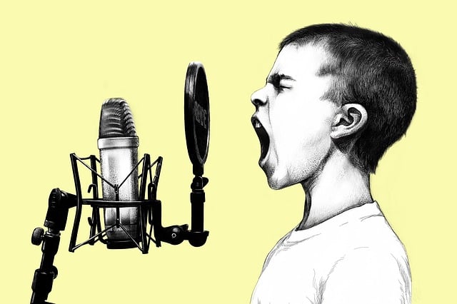 boy yelling into microphone on a yellow background