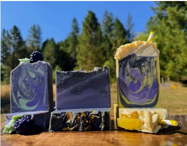 bars of soap arranged with berries in a nature setting.